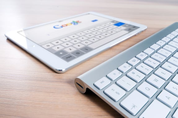 A tablet displaying the Google search page next to a keyboard to represent on-page SEO solutions